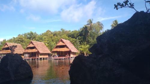 a group of huts on a body of water at Beser Bay Homestay in Besir