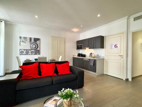 - un salon avec un canapé noir et des oreillers rouges dans l'établissement Dimora André By SCLS Locations, à Cannes