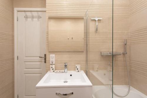 une salle de bain blanche avec un lavabo et une douche dans l'établissement L38 Hobeika Suite Fleur 7min Walk To Beach,Free Park,Balc&AC, à Nice