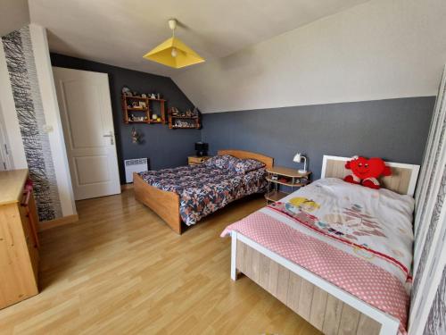 - une chambre avec 2 lits dans une pièce aux murs bleus dans l'établissement chambres évènements circuit LE MANS, à La Milesse