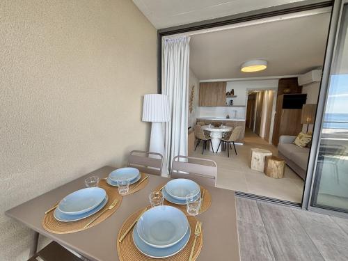 - une salle à manger avec une table et des assiettes dans l'établissement Appartement Eden B sanguinaires vue mer avec piscine résidence, à Ajaccio