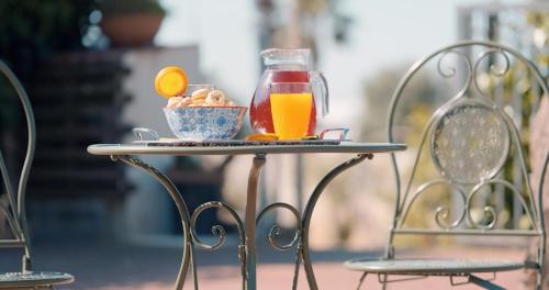 a table with a pitcher of juice and a bowl of fruit at B&B CASA NISI in Villa Castelli