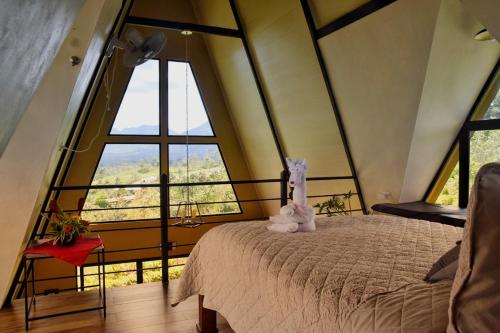 a bedroom with a bed in a room with large windows at Alma Luna Villa Arenal in Monterrey