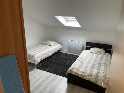 Cette petite chambre comprend deux lits et une lucarne. dans l'établissement Floor of a house apartment F3, à Cormeilles-en-Parisis