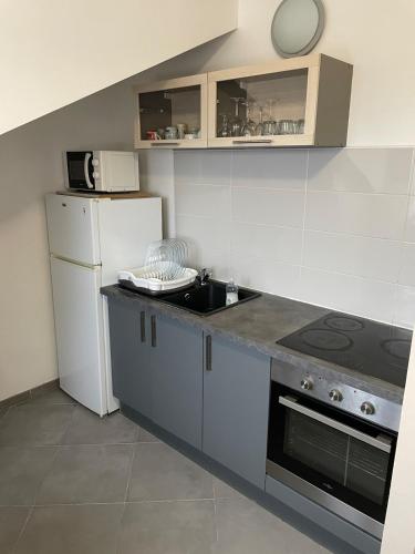 une cuisine avec un réfrigérateur blanc et un évier dans l'établissement Floor of a house apartment F3, à Cormeilles-en-Parisis