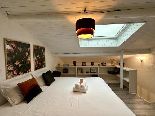 - une chambre avec un grand lit blanc et une lucarne dans l'établissement Le Vintage - Duplex - 2 à 4 personnes - Proche Gare, à Nancy