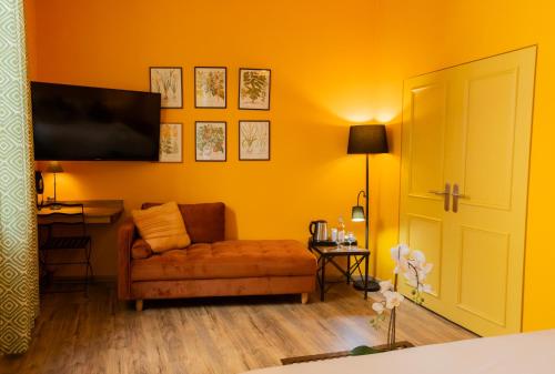 a living room with a couch and a flat screen tv at Garlande Hôtel Avignon Centre in Avignon