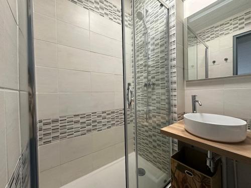 une salle de bain avec un lavabo et une douche en verre dans l'établissement Le Vintage - Duplex - 2 à 4 personnes - Proche Gare, à Nancy