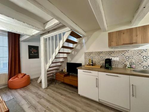 une cuisine avec des placards blancs et un escalier en colimaçon dans l'établissement Le Vintage - Duplex - 2 à 4 personnes - Proche Gare, à Nancy