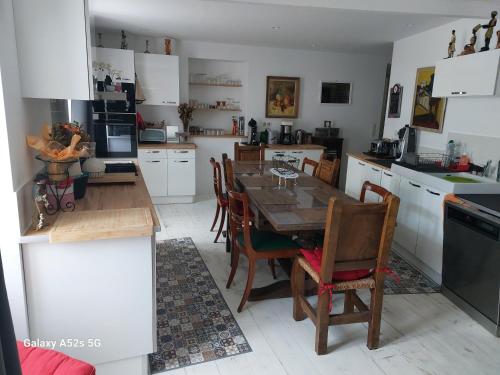une cuisine avec une table et des chaises et une cuisine avec des armoires blanches dans l'établissement ARDECHE, Maison de vacances bensylv privative 4 adultes et 2 enfants 3 chambres, 4 lits, à Labégude