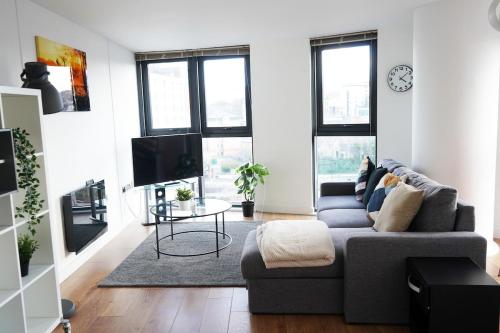 a living room with a couch and a tv at Opulent Apartment City Centre in Sheffield