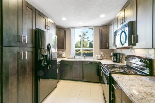 a kitchen with dark wood cabinets and a window at La Palme Urban Chic in Palm Springs