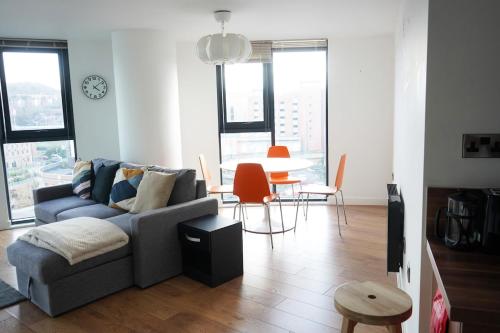 ein Wohnzimmer mit einer Couch und einem Tisch mit Stühlen in der Unterkunft Opulent Apartment City Centre in Sheffield