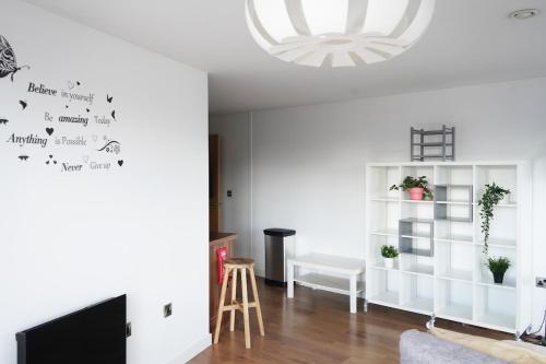 a living room with white walls and a chandelier at Opulent Apartment City Centre in Sheffield