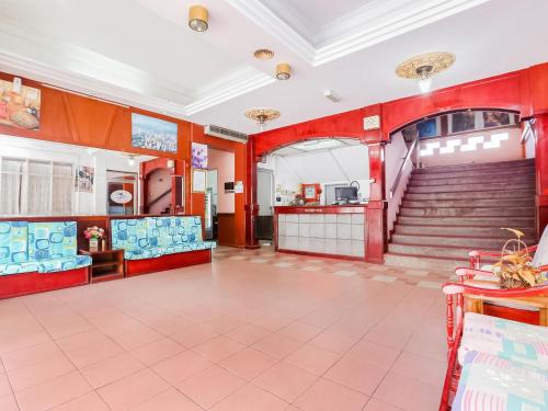 a large room with red walls and stairs at Hotel O Green Mango @ Sri Cemerlang in Kota Bharu
