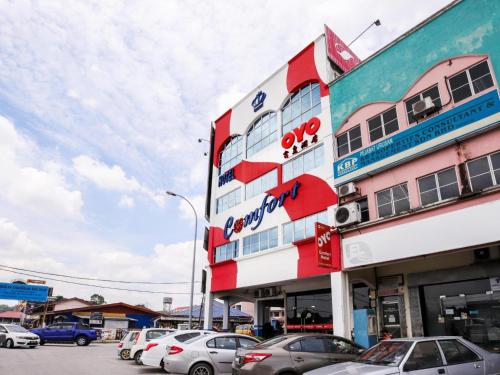 a building with cars parked in a parking lot at Hotel O 340 Comfort Hotel in Kampong Batu Belah