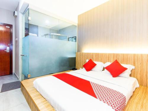 a bedroom with a large bed with red pillows at Hotel O 340 Comfort Hotel in Kampong Batu Belah