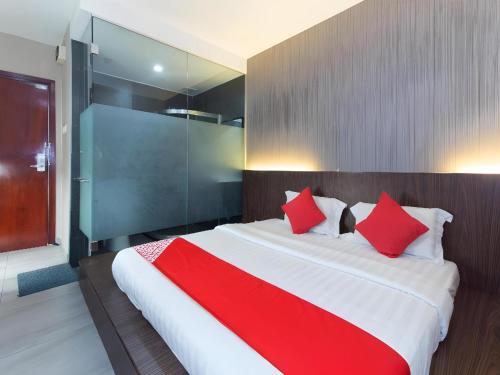 a bedroom with a large bed with red pillows at Hotel O 340 Comfort Hotel in Kampong Batu Belah