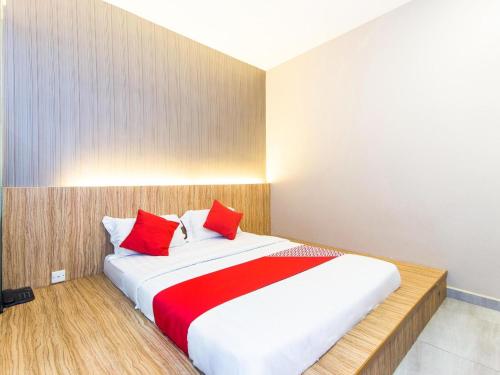 a bedroom with a large bed with red pillows at Hotel O 340 Comfort Hotel in Kampong Batu Belah
