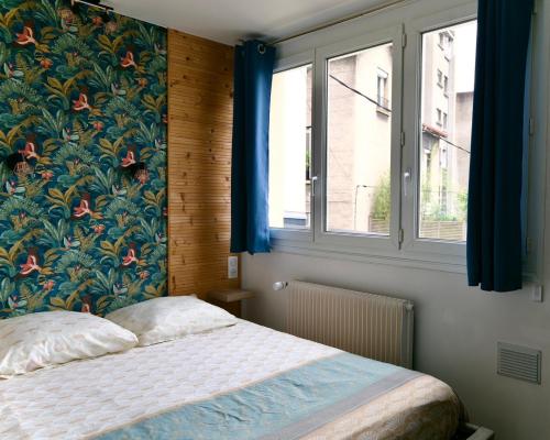 une chambre avec un lit avec un papier peint fleuri dans l'établissement Saint-Étienne Bellevue Confort 1, à Saint-Étienne