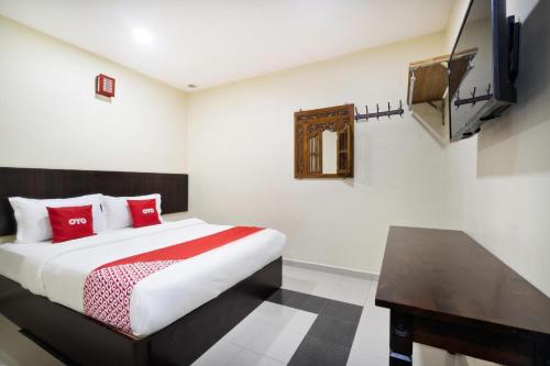 a bedroom with a bed and a television in it at OYO 89960 Manjung Inn Hotel in Seri Manjung