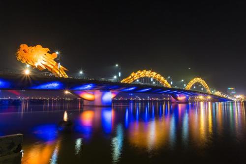 a bridge over the water at night with lights at Thien Han Phat Hotel in Da Nang