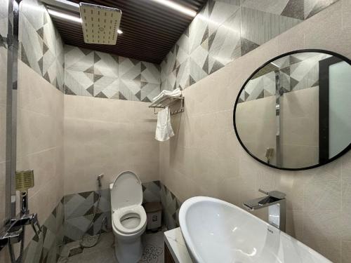 a bathroom with a sink and a toilet and a mirror at Thien Han Phat Hotel in Da Nang