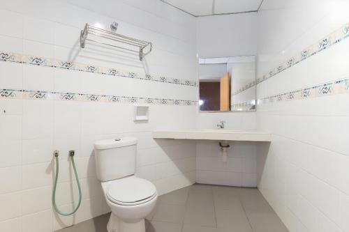 a white bathroom with a toilet and a sink at Super OYO 447 Comfort Hotel Meru in Klang