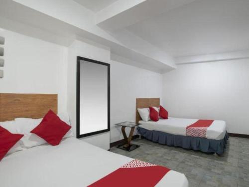a hotel room with two beds and a mirror at Casa Venicia Caticlan in Boracay