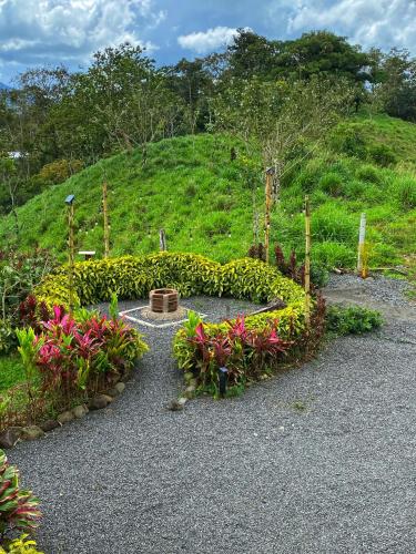 a garden with flowers in front of a hill at Alma Luna Villa Arenal in Monterrey