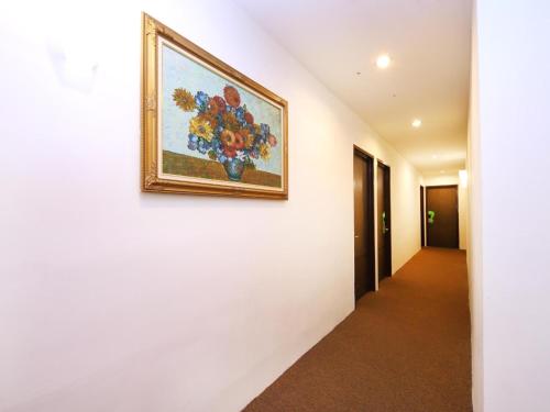 a painting of flowers on a wall in a hallway at Hotel O Marvelton Hotel in Butterworth