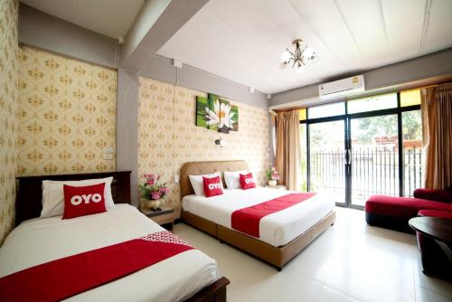 a hotel room with two beds and a window at OYO 465 Krung Kao Traveller Lodge in Phra Nakhon Si Ayutthaya