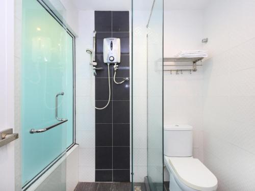 a bathroom with a toilet and a glass shower at Hotel O Marvelton Hotel in Butterworth