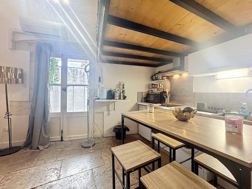 une cuisine avec une table et des chaises dans une pièce dans l'établissement Le studio Mezz, charmant studio avec mezzanine, à Montpellier