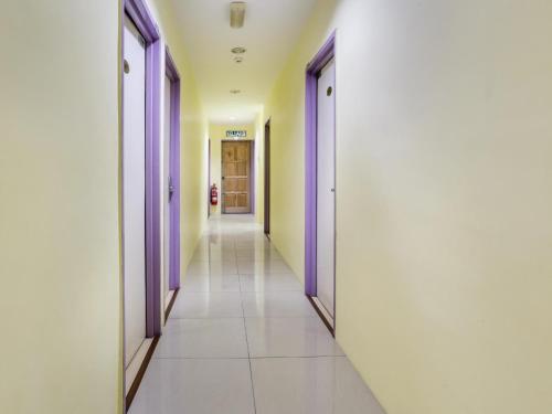 a corridor of a hospital hallway with purple doors at OYO 89583 Grove Hotel in Kajang