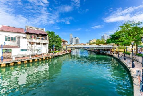 a river in a city with a bridge at Capital O 90756 Cara Hulu Hotel in Kampong Morten