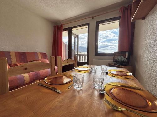 une table de salle à manger avec des assiettes et des verres dessus dans l'établissement Studio cosy à 50m des pistes, balcon, parking, casier à skis, proche village et école de ski - FR-1-595-11, à Notre-Dame-de-Bellecombe