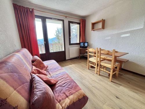 un salon avec un canapé et une table dans l'établissement Studio cosy à 50m des pistes, balcon, parking, casier à skis, proche village et école de ski - FR-1-595-11, à Notre-Dame-de-Bellecombe