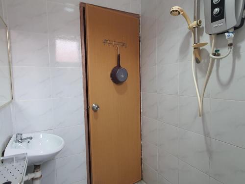 a bathroom with a toilet and a sink and a door at Hotel O Melody 88 Inn in Miri