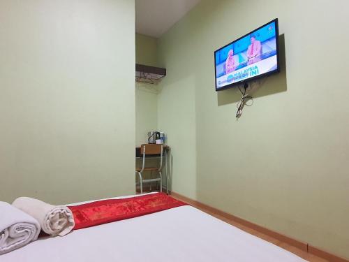 a room with a bed and a tv on the wall at Hotel O Melody 88 Inn in Miri