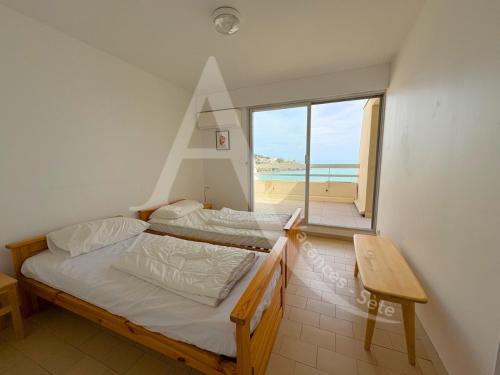 - 2 lits dans une chambre avec vue sur la plage dans l'établissement 6 PERS, 2 CHAMBRES, DERNIER ETAGE EN FRONT DE MER, à Sète