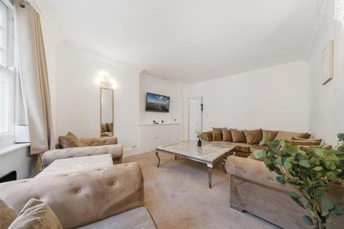 a living room with a couch and a table at Prime Soho 3-Bedroom Apartment Steps from Piccadilly and Chinatown! No Lift 3GH in London