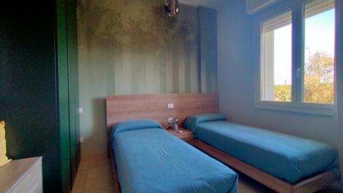 a bedroom with two beds and a window at Appartamento trilocale FRONTE MARE con SPIAGGIA INCLUSA Taunus vacanze cod 494 in Marcelli