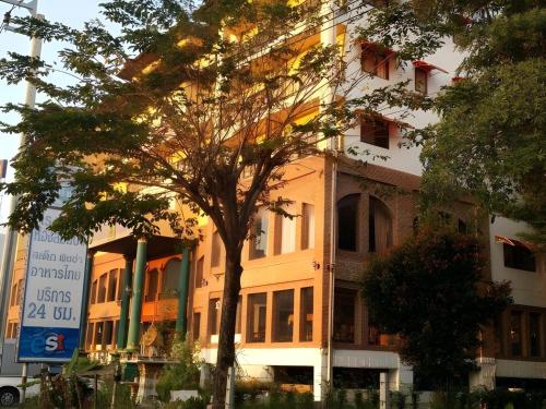 a building with a tree in front of it at OYO 75466 -13 Coins Bang Yai Hotel in Ban Sai Ma