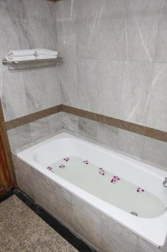 a bathroom with a bath tub with flowers on it at OYO 75466 -13 Coins Bang Yai Hotel in Ban Sai Ma