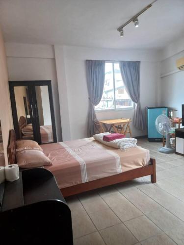 a bedroom with a bed and a large window at OYO 75474 Funkey Fulung Andy & Tan Guest House in Pattaya Central