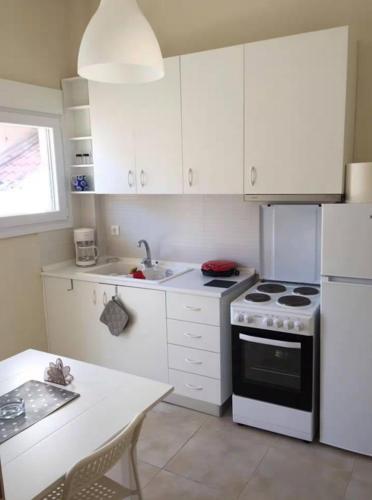 a kitchen with white cabinets and a white stove and refrigerator at Enchanting Sea View in Kallithea Halkidikis