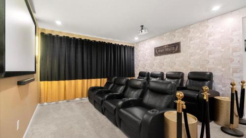 a waiting room with black leather chairs and a screen at Upstay Family Home w Pool, Cinema & Games Room in Kissimmee