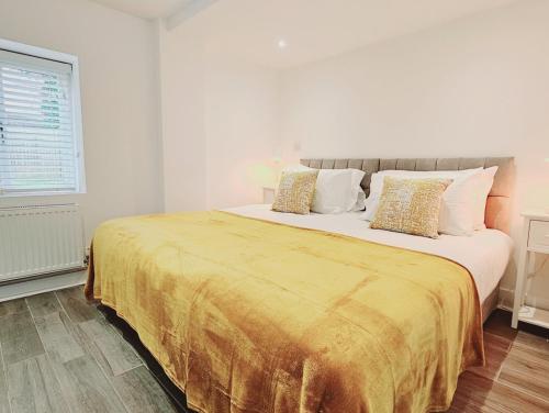 Un dormitorio con una cama grande con una manta amarilla. en The Oak Suite, en Farnham