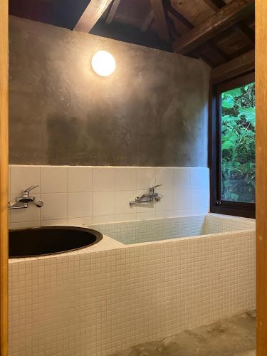 a bathroom with a sink and a window at Habuman Okinawa in Kunigami